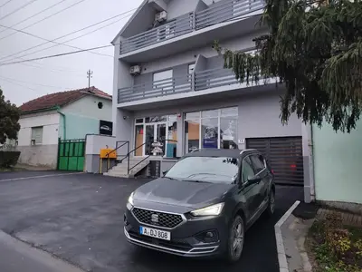 a car parked in a parking lot in front of a house at IMPERIUM stan na dan in Inđija