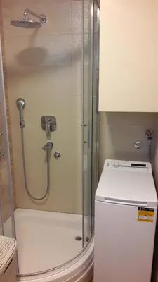 a shower with a glass door next to a toilet at Apartment Dedinje Hill 2 in Belgrade