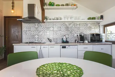 a kitchen with a white table and green chairs at LIPA houses & spa in Sopot
