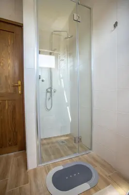 a bathroom with a shower with a glass door at LIPA houses & spa in Sopot