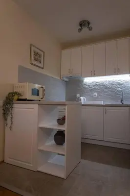 a kitchen with white cabinets and a microwave at Classico apartment Belgrade in Voždovac