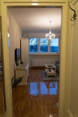 a living room with a refrigerator and a chandelier at Classico apartment Belgrade in Voždovac