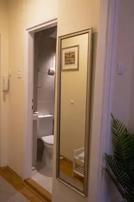 a bathroom with a mirror next to a toilet at Classico apartment Belgrade in Voždovac