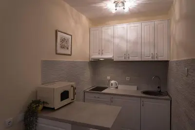 a kitchen with white cabinets and a microwave at Classico apartment Belgrade in Voždovac