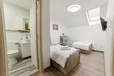 a bathroom with two beds and a toilet and a sink at Apartmani Statik SD in Smederevo