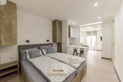 a bedroom with a large bed and a kitchen at Apartmani Statik SD in Smederevo