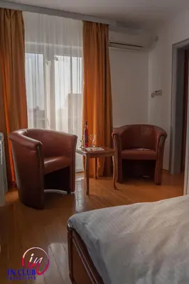 a hotel room with two chairs and a bed and a table at Apartment and Rooms In Club in Inđija
