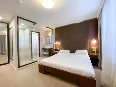 a bedroom with a large bed and a large mirror at Luka de Luka Suites in Belgrade