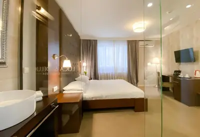 a hotel room with a bed and a sink and a tub at Luka de Luka Suites in Belgrade