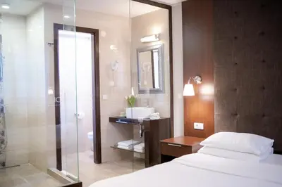 a bathroom with a bed and a glass shower at Luka de Luka Suites in Belgrade