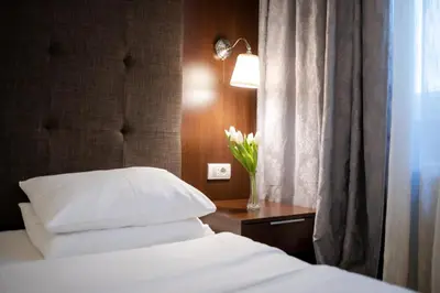 a bedroom with a bed and a vase of flowers on a table at Luka de Luka Suites in Belgrade