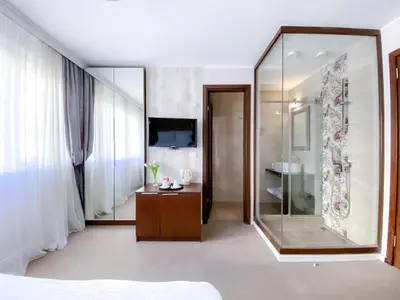 a bedroom with a large mirror and a shower at Luka de Luka Suites in Belgrade