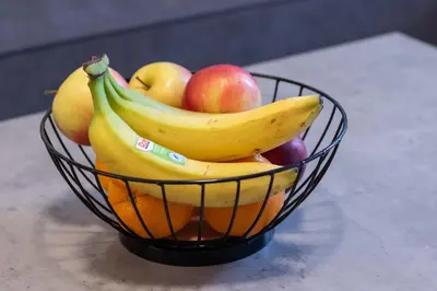 a bowl of fruit with bananas apples and oranges at Apartment Garden in Belgrade