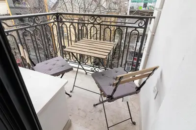 a balcony with a wooden table and two chairs at Apartment Garden in Belgrade