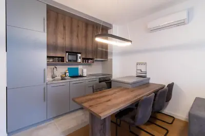 a kitchen with a wooden table and chairs at Apartment Garden in Belgrade