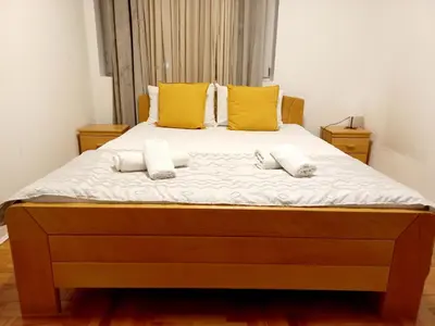 a large bed with two pillows and two towels at Apartment Alex in Belgrade