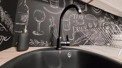 a black sink with a faucet and a wine glass at Apartman 23 in Belgrade