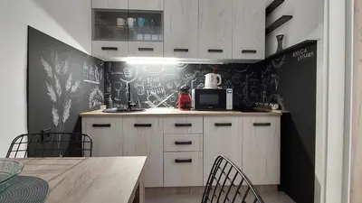 a kitchen with white cabinets and a black wall at Apartman 23 in Belgrade