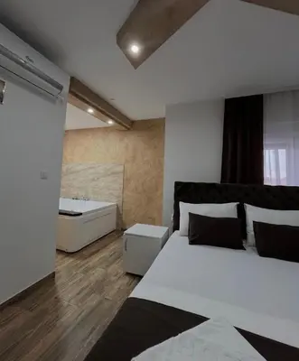 a bedroom with a white bed and a bath tub at Sobe i Apartmani Casa Mia in Pećinci