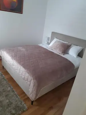a bedroom with a bed with a brown comforter at Apartman Magija in Arandjelovac