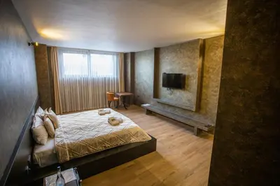 a hotel room with a bed and a television at Monogramlux in Inđija