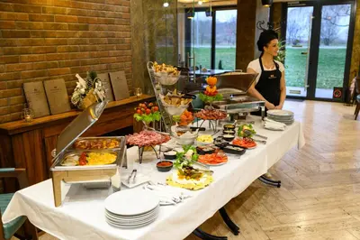 a woman standing next to a table with food at Monogramlux in Inđija