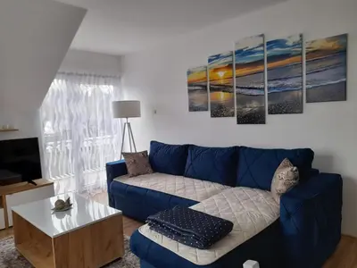 a living room with a blue couch and a table at Apartman Giovanni in Arandjelovac