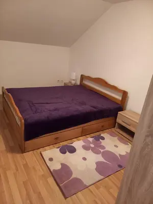 a bedroom with a purple bed and a rug at Apartman Giovanni in Arandjelovac