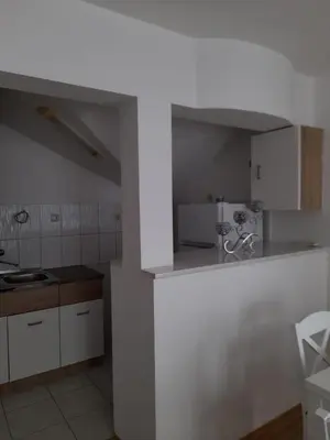 a kitchen with white cabinets and a counter top at Apartman Giovanni in Arandjelovac