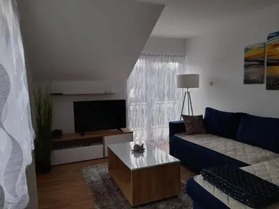 a living room with a blue couch and a tv at Apartman Giovanni in Arandjelovac