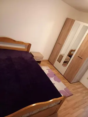 a bedroom with a bed and two open doors at Apartman Giovanni in Arandjelovac