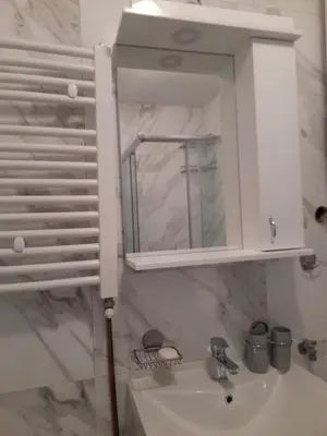 a bathroom sink with a mirror and a cabinet at Apartman Giovanni in Arandjelovac