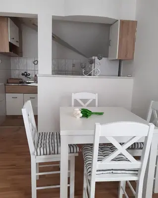 a white dining room table and chairs in a kitchen at Apartman Giovanni in Arandjelovac