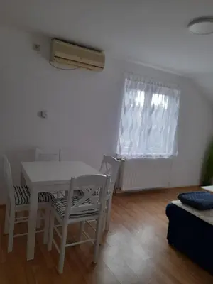 a living room with a table and chairs and a window at Apartman Giovanni in Arandjelovac