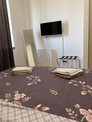 a bedroom with a bed with a purple blanket with flowers on it at Aurora BW in Belgrade