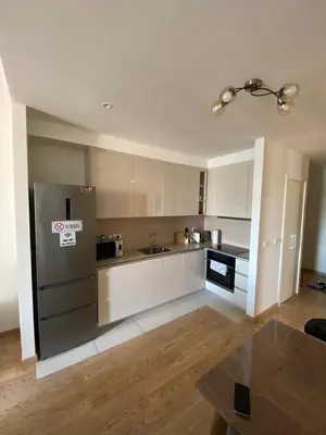 a kitchen with white cabinets and a stainless steel refrigerator at Aurora BW in Belgrade