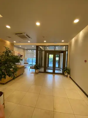 an office lobby with a large tile floor and glass doors at Aurora BW in Belgrade