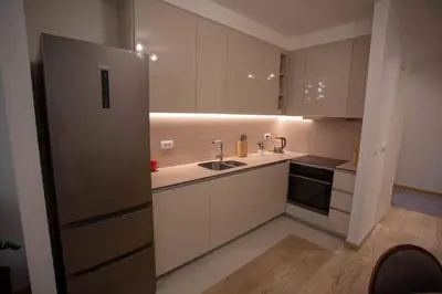 a kitchen with white cabinets and a stainless steel refrigerator at Aurora BW in Belgrade