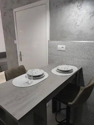 a table with two plates and a glass on it at Flora Apartment in Surčin