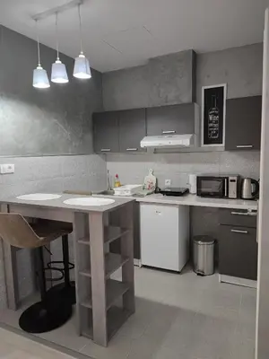 a kitchen with a table and a counter top at Flora Apartment in Surčin