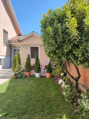 a house with plants in front of a yard at Flora Apartment in Surčin