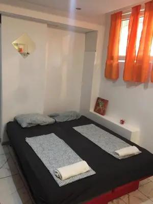 two beds in a room with orange curtains at Stadion in Belgrade