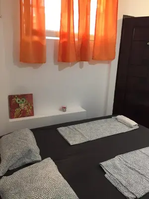 a bedroom with orange curtains and a bed with two mats at Stadion in Belgrade