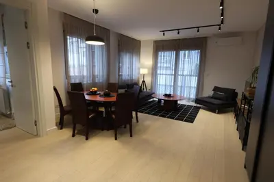 a living room and dining room with a table and chairs at Modern apartment in the heart of Belgrade in Belgrade