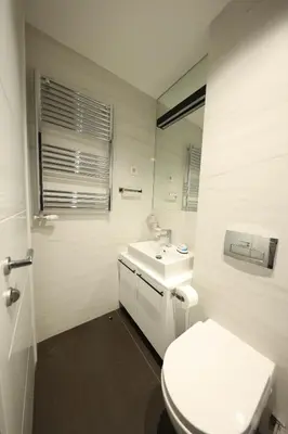a white bathroom with a toilet and a sink at Modern apartment in the heart of Belgrade in Belgrade