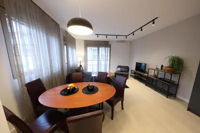 a living room with a wooden table and a dining room at Modern apartment in the heart of Belgrade in Belgrade