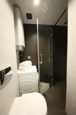 a bathroom with a toilet and a glass shower at Modern apartment in the heart of Belgrade in Belgrade