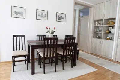 a dining room with a wooden table and chairs at New Belgrade apartment in Belgrade