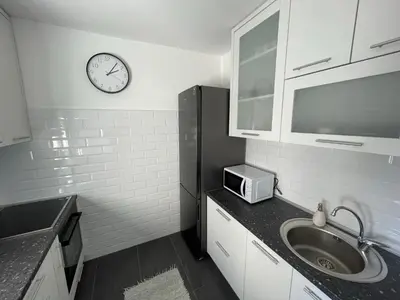a kitchen with a sink and a clock on the wall at New Belgrade apartment in Belgrade