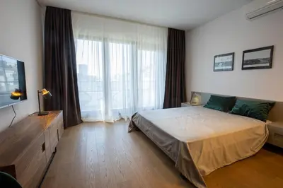 a bedroom with a large bed and a large window at Belgrade Center Apartment Lux Residence in Belgrade
